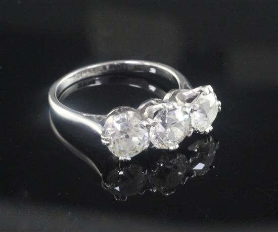 A mid 20th century platinum and three stone diamond ring, size L.